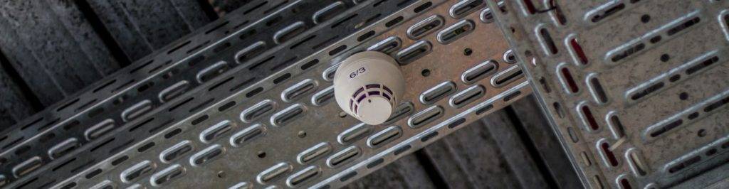 fire alarm installed on to ceiling metal beams