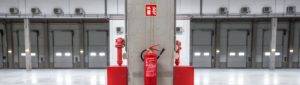 fire extinguisher on warehouse pillar with signage above