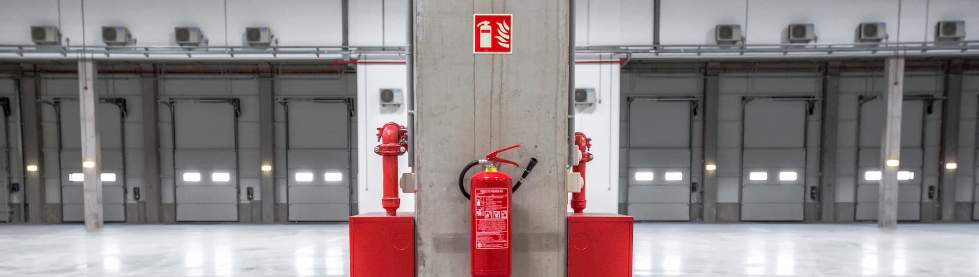 fire extinguisher on warehouse pillar with signage above