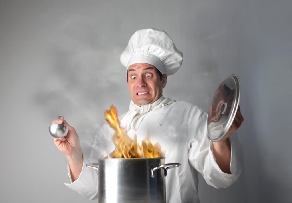 Chef panicking over a cooking pot fire
